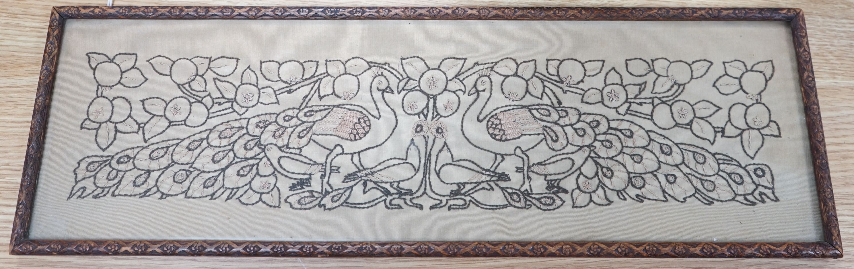 An Arts & Crafts peacock framed embroidered panel, 15.5cms high x 54.5cms wide